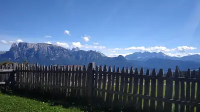a wooden fence with mountains in the background at Oberpfaffstaller in Longomoso