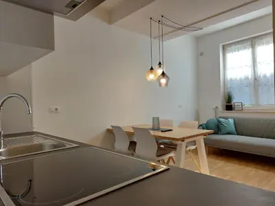a kitchen and living room with a table and a couch at Villa Trogmann in Merano
