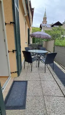 a table and chairs with an umbrella on a patio at Villa Trogmann in Merano