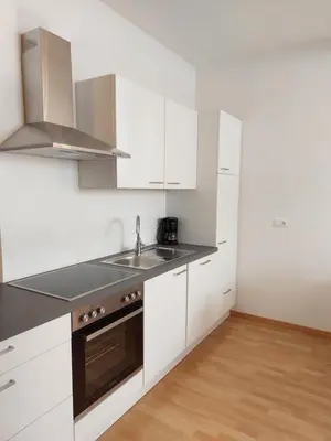 a kitchen with white cabinets and a sink at Villa Trogmann in Merano