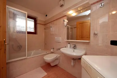a bathroom with a toilet and a sink and a tub at Cesa Mattias - Appartamenti a Canazei in Canazei