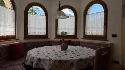 a room with a table with a vase of flowers on it at Cesa Mattias - Appartamenti a Canazei in Canazei