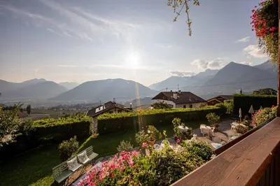 a view of a garden with mountains in the background at Panorama Hotel St Georgen in Schenna