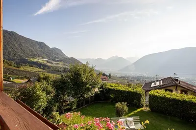 a view of a garden with mountains in the background at Panorama Hotel St Georgen in Schenna