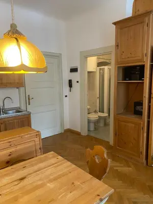 a kitchen with a table and a sink and a toilet at Appartament Brennero in Colle Isarco
