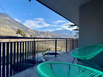 a balcony with two chairs and a view of the mountains at Apart Suites Gravbach in Lagundo