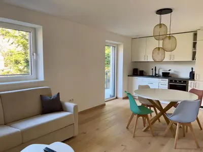 a living room with a couch and a table and chairs at Apart Suites Gravbach in Lagundo