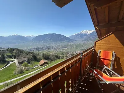 a room with a balcony with a view of mountains at Hotel Rastlhof in Schenna