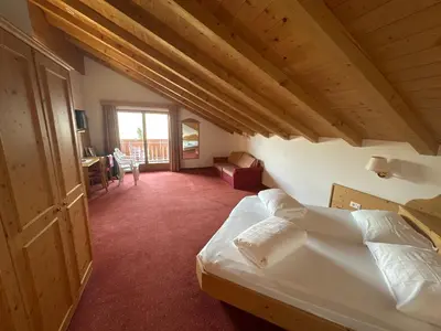 a bedroom with a bed and a desk in a room at Hotel Rastlhof in Schenna