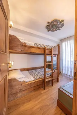 a bedroom with bunk beds in a cabin at Casa Cristallino, in centro con balcone panoramico in Cortina dʼAmpezzo