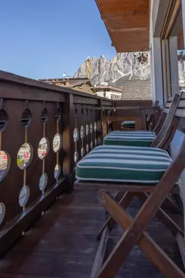 a deck with chairs and paddles on a house at Casa Cristallino, in centro con balcone panoramico in Cortina dʼAmpezzo