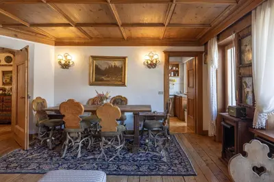 a dining room with a wooden table and chairs at Casa Cristallino, in centro con balcone panoramico in Cortina dʼAmpezzo