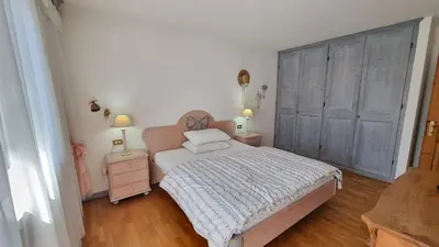 a bedroom with a bed and two dressers and two lamps at Anto in Campitello di Fassa