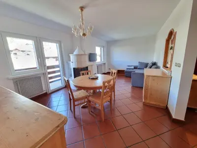 a kitchen and living room with a table and chairs at Anto in Campitello di Fassa