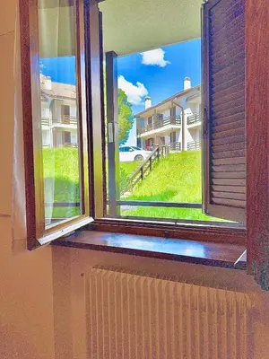 an open window with a view of a building at Il Moro di Cavalese in Castello di Fiemme