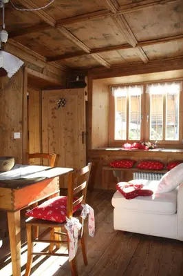 a living room with a table and a couch at la fusinela in Selva di Cadore