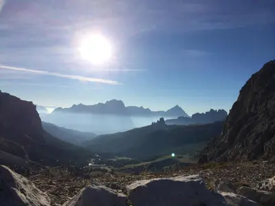 a view of a valley with the sun in the sky at la fusinela in Selva di Cadore