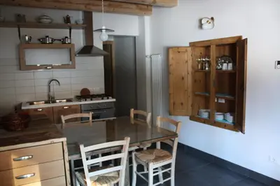 a kitchen with a table and chairs and a sink at la fusinela in Selva di Cadore