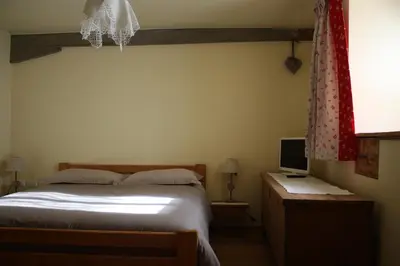 a bedroom with a bed and a desk with a television at la fusinela in Selva di Cadore