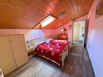 a bedroom with a red bed and a skylight at Appartamento Franca in Pera