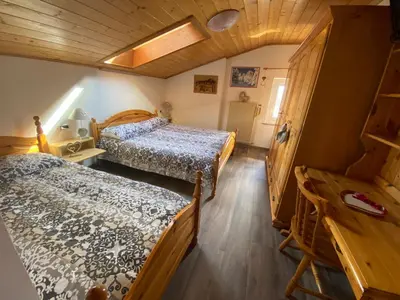 a bedroom with two beds and a wooden ceiling at Appartamento Franca in Pera