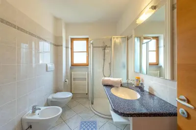 a bathroom with a sink and a toilet and a shower at Quellenhof in Appiano sulla Strada del Vino