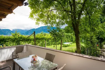 a table and chairs on a balcony with a view at Quellenhof in Appiano sulla Strada del Vino