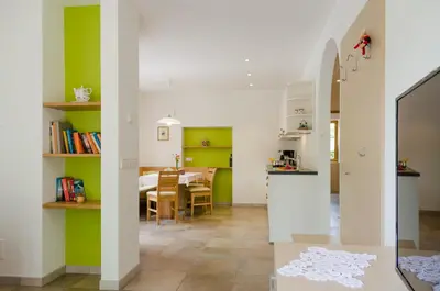 a kitchen and dining room with green and white walls at Quellenhof in Appiano sulla Strada del Vino