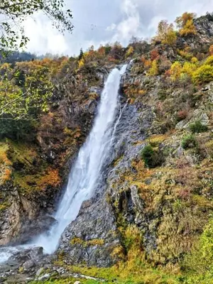a waterfall on the side of a rocky mountain at Cafe Rudi Living Apartements in Parcines