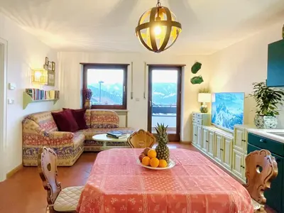 a living room with a table with a bowl of fruit on it at Apartment in South Tyrol with a beautiful panoramic view in Verano