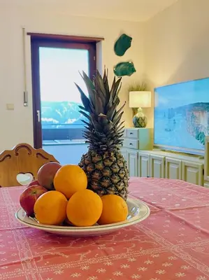 a plate of fruit on a table with a pineapple at Apartment in South Tyrol with a beautiful panoramic view in Verano