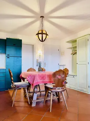 a dining room with a pink table and chairs at Apartment in South Tyrol with a beautiful panoramic view in Verano