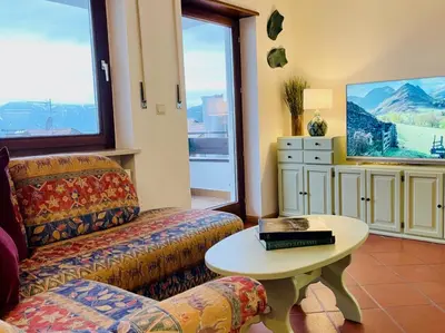 a living room with a couch and a table at Apartment in South Tyrol with a beautiful panoramic view in Verano