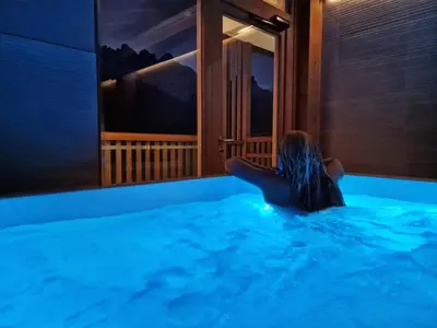 a woman in a swimming pool looking out a window at Residence Panorama in Val di Zoldo