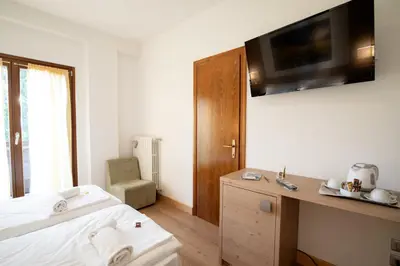 a bedroom with a bed and a tv on the wall at Residence Panorama in Val di Zoldo