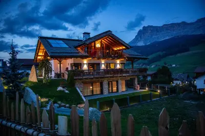 a house on top of a hill with a fence at Chalet Stefan - Apartments in La Villa