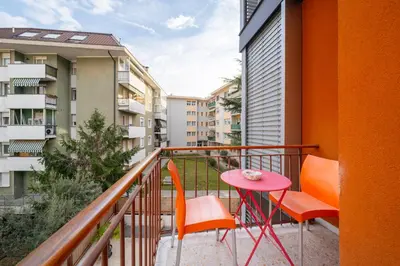 a balcony with a table and chairs and buildings at Gardar in Bolzano