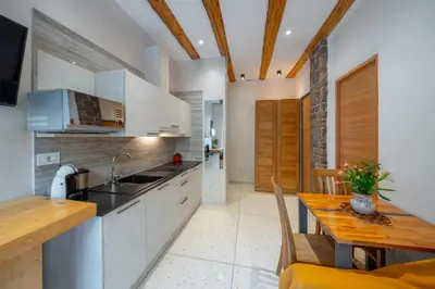 a kitchen with a wooden table and a dining room at Gardar in Bolzano