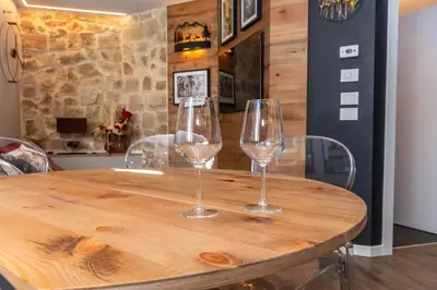 two wine glasses sitting on top of a wooden table at Casa Te Volto in Moena