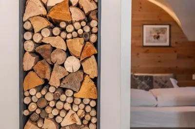 a room with a wall of fire wood at Casa Te Volto in Moena