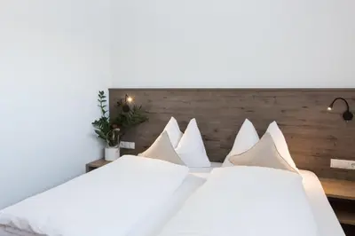 a bedroom with two beds with white pillows at Hotel Föhrenhof in Naz-Sciaves