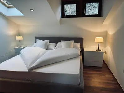 a bedroom with a bed with white sheets and two lamps at Bergchalet Platzl in Verano
