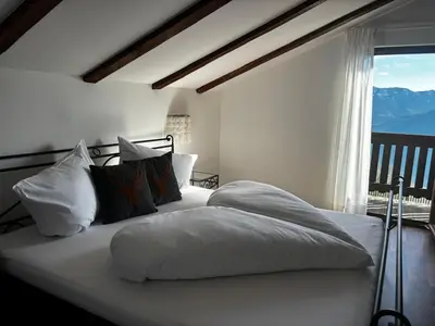 a white bed with pillows and a window in a bedroom at Bergchalet Platzl in Verano