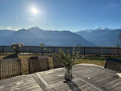 a vase on a wooden table with a view of mountains at Bergchalet Platzl in Verano