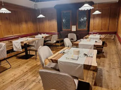 a restaurant with wooden walls and tables and chairs at Santer Klause in Merano