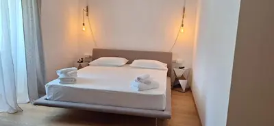 a bedroom with a bed with white sheets and towels at Santer Klause in Merano