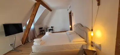 a bedroom with a white bed and a television at Santer Klause in Merano
