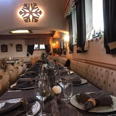 a long dining room with a long table with wine glasses at Rifugio Caltena in Fiera di Primiero