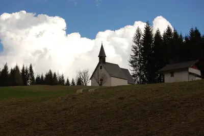 a church sitting on top of a hill at Rifugio Caltena in Fiera di Primiero