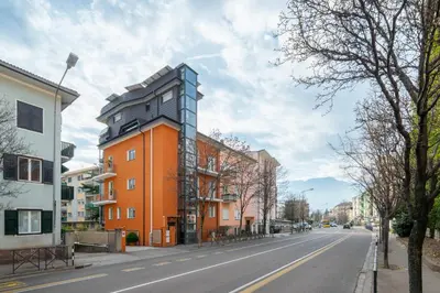 an orange building with a black roof on a street at Gardar Studio Fox in Bolzano